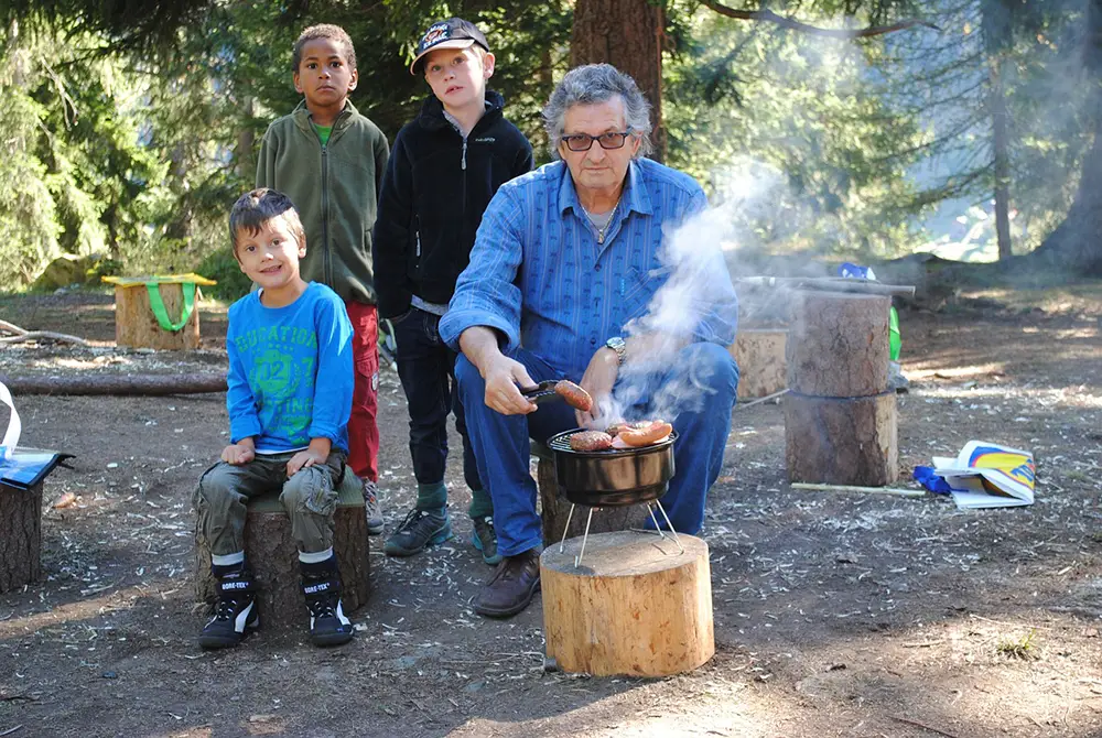Grand-père qui fait un barbecue en compagnie de ses enfants