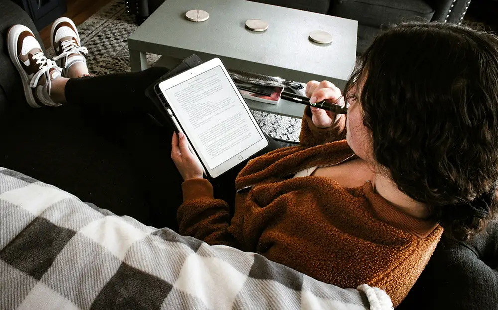 lecture d'un ebook sur une tablette, tranquillement allongé sur un canapé