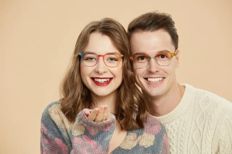 Un homme et une femme souriants portant des lunettes aux verres progessifs