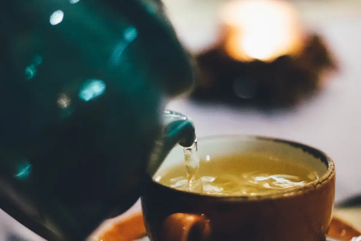 tisane au tilleul versées dans une tasse avec une théière