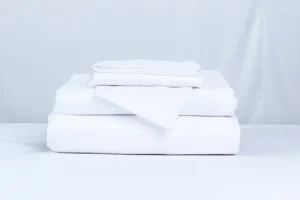 linge de literie (draps, taies d'oreillers ) bien pliée pour illustrer la gestion du linge en entreprise