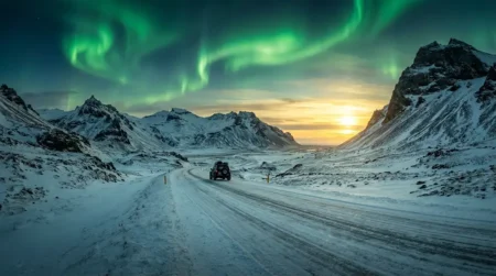 Road trip en Islande en hiver : itinéraire de 7 jours sur la Ring Road Route enneigée en Islande en hiver avec montagnes volcaniques et aurores boréales vertes dans le ciel