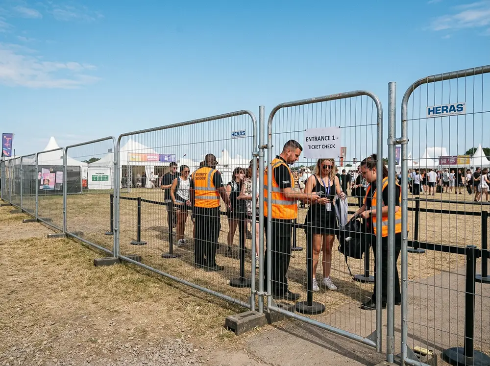 Panneaux de cl&ocirc;ture grillag&eacute;e HERAS d&eacute;limitant le p&eacute;rim&egrave;tre d'un &eacute;v&eacute;nement ext&eacute;rieur avec points de contr&ocirc;le d'acc&egrave;s