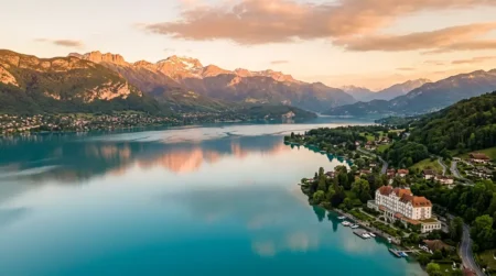 Vue aérienne du lac d'Annecy au coucher du soleil entouré des Alpes françaises, cadre idéal pour un séjour ressourçant