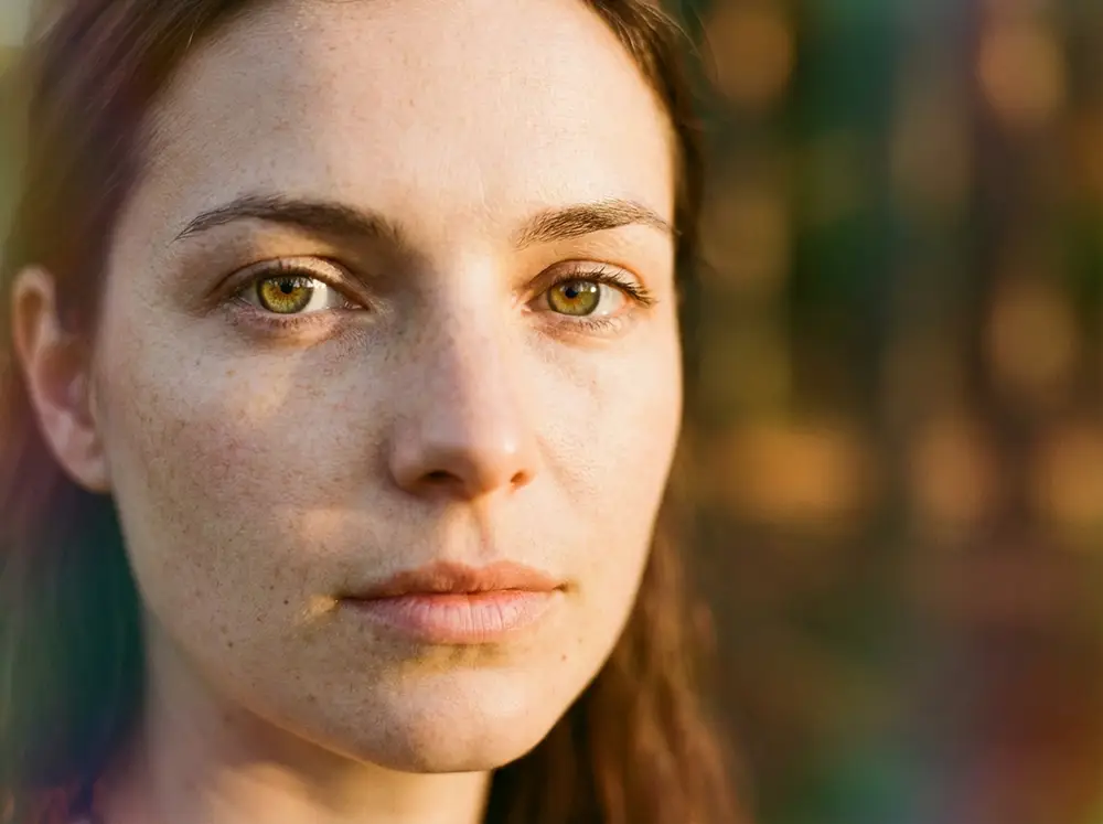 Portrait en lumi&egrave;re dor&eacute;e d'une femme aux yeux hazel au regard expressif et myst&eacute;rieux