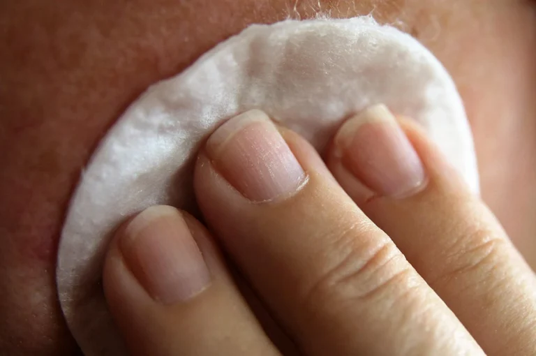 Application d'une crème bio avec un coton pour le soin du visage